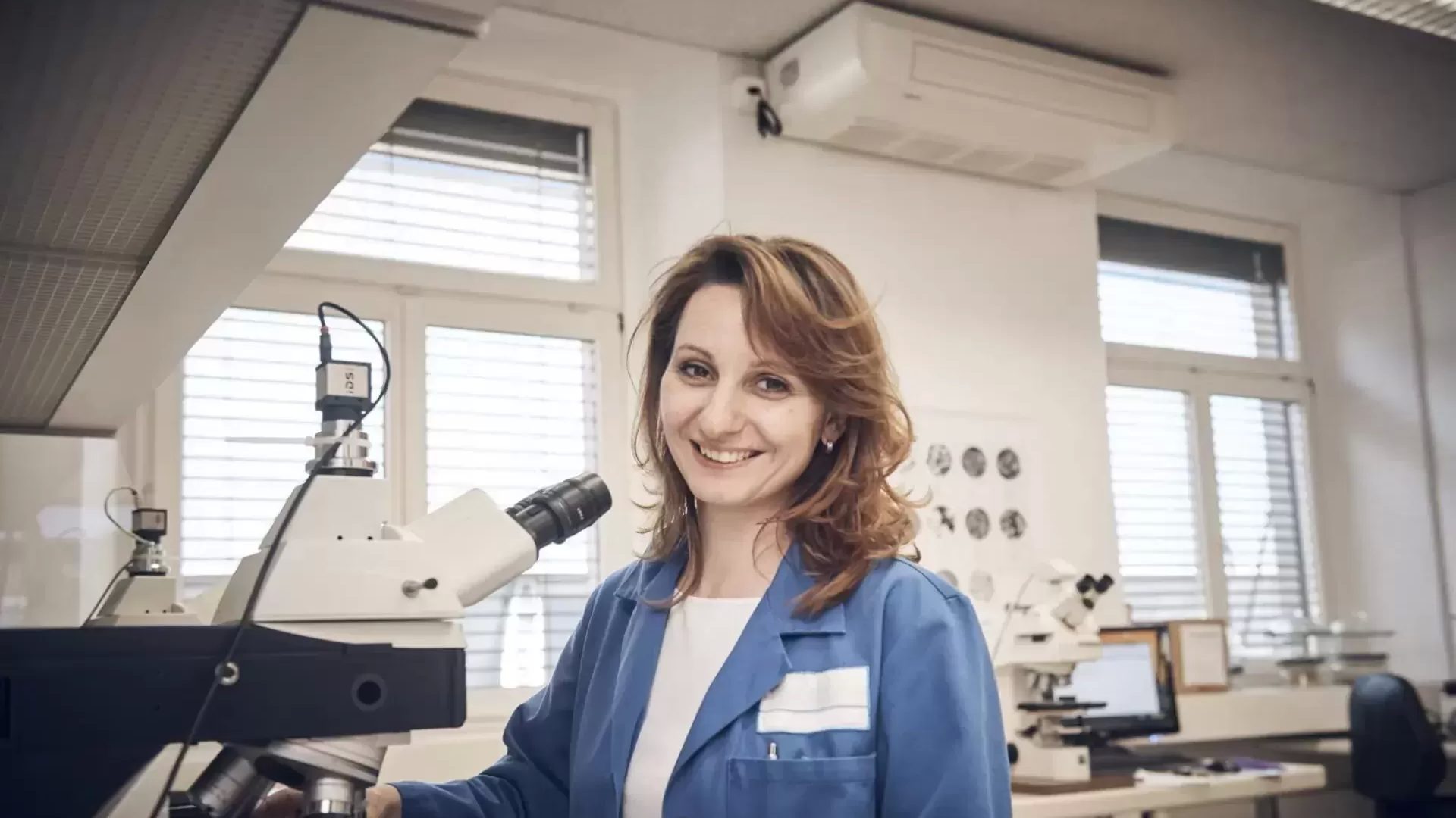 Wissenschaftlerin mit mikroskop im labor