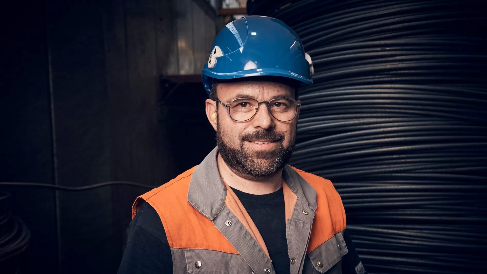 Arbeiter mit sicherheitsausruestung vor stahlcoils